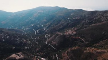 Yunanistan 'ın Girit kentindeki Topolia Gorge dağ vadisinde, içinden yılan yolu geçen hava manzarası. Yüksek kalite 4k görüntü