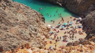 Seitan Limania plajının üzerindeki büyüleyici manzarada turistler Yunanistan 'ın Girit kentinde günlerinin tadını çıkarıyorlar. Yüksek kalite 4k görüntü