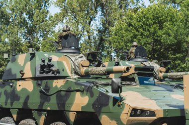 Askeri kuvvetler konsepti. Ağaçların arkasına karşı iki küçük tankın üzerinde askerler var. Yüksek kalite fotoğraf