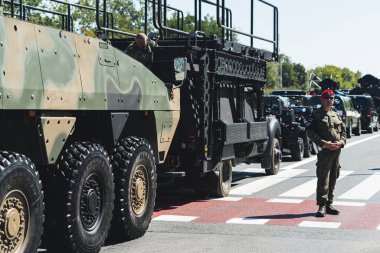 16.08.2023 Varşova, Polonya. Askeri sütun kavramı. Kırmızı bereli erkek asker askeri geçit töreni sırasında modern ordu araçlarının geçişini koruyor. Yüksek kalite fotoğraf
