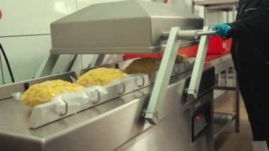 Yiyecek endüstrisi çalışanı, taze patatesleri özel plastik poşetlere koymak için Azaltılmış Oksijen Paketleme Makinesi kullanıyor. Yüksek kalite 4k görüntü