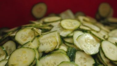 Endüstriyel bir öğütücü tarafından doğranan ince dilimlenmiş taze salatalıkların yakın plan çekimi. Yemek hazırlama konsepti. Yüksek kalite 4k görüntü