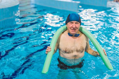 Mayolu ve koruyucu gözlüklü emekli adam modern kapalı havuzda çalışıyor. Yüksek kalite fotoğraf