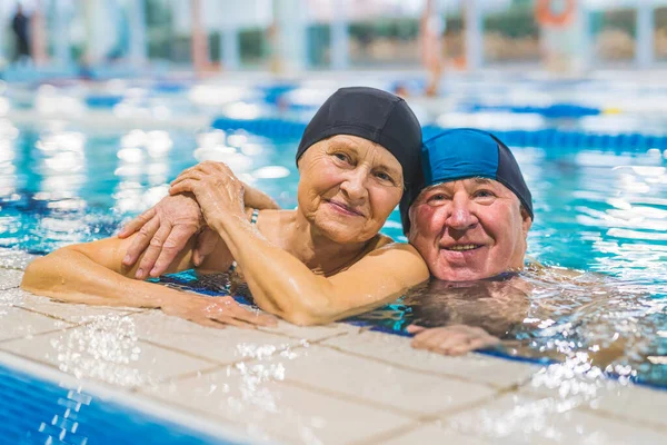 cute portrait of an aged Caucasian couple looking satisfied from the indoor pool, wellbeing concept. High quality photo