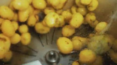 Taze temiz yiyecekler. Patates temizleme işlemi. Bir sürü sarı patates etrafa saçılıyor ve su sıçrıyor. Yüksek kalite 4k görüntü