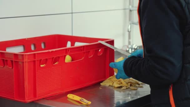 ゴム製保護手袋のキッチンスタッフの従業員は ナイフでジャガイモを洗って剥がします レストランライフコンセプト 高品質の4K映像 — ストック動画