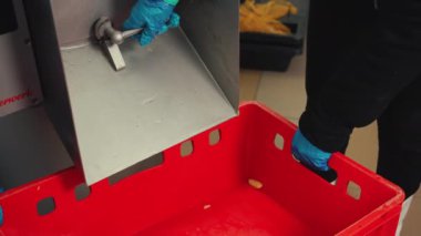 Çalışanlar taze ve temiz sarı patatesleri patates makinesinden kırmızı plastik konteynıra boşaltıyorlar. Yemek hazırlama ve restoran hayatı. Yüksek kalite 4k görüntü