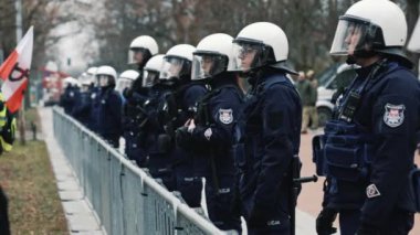 06.03.2024. Varşova, Polonya. Koyu renk üniformalı ve kasklı polis memurları protesto sırasında çiğ olarak duruyorlar. Yüksek kalite 4k görüntü