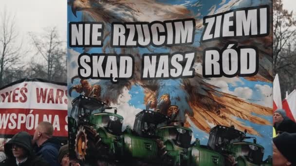 2024 波兰华沙 穿着保暖衣服的男人举着光彩夺目的旗帜和海报 上面有拖拉机和文字 高质量的4K镜头 — 图库视频影像