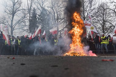 06.03.2024. Warsaw, Poland. polish protestors with flags and posters standing around a big fire. High quality photo clipart