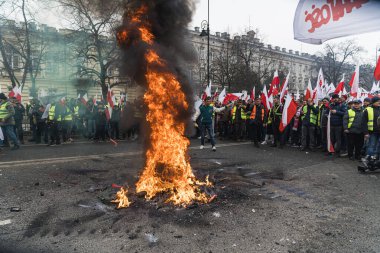 06.03.2024. Varşova, Polonya. Polonyalı çiftçiler ve vatandaşlar ateşin etrafında toplandı ve bayraklar ve pankartlarla protesto ettiler. Yüksek kalite fotoğraf