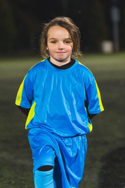 ... futbol mavi üniforması giyen ve stadyumda poz veren beyaz bir kız. Yüksek kalite fotoğraf