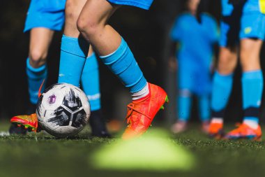 Mavi üniformalı ve çoraplı çocukların sahada topa vuruşları, çocukların futbol konsepti. Yüksek kalite fotoğraf