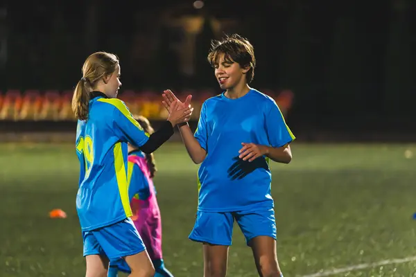 medium shot of young soccer players shaking hands and congratulating win, children sports concept. High quality photo