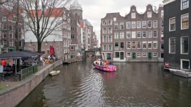 Kanalda bir tekne ve Amsterdam 'da kafeler, Hollanda' da turistik yerler. Yüksek kalite 4k görüntü