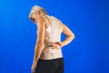 İnsan vücudunda ortopedik korse, sırt ağrısı ve yara bakımı, mavi arka plan, sağlık sigortası. Yüksek kalite fotoğraf