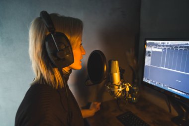 Young woman working as a presenter at a radio station, medium side view shot, podcasting studio. High quality photo clipart