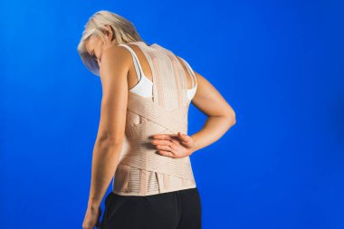 İnsan vücudunda ortopedik korse, sırt ağrısı ve yara bakımı, mavi arka plan, sağlık sigortası. Yüksek kalite fotoğraf
