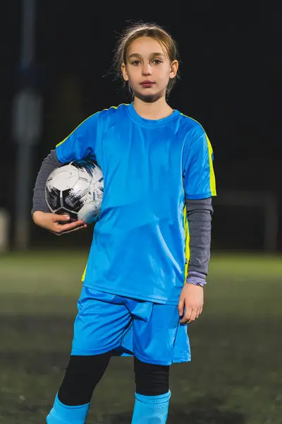 medium-full shot of a soccer player cute little girl with a ball, athlete and active kids concept. High quality photo
