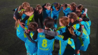 Üniformalı küçük kızların yüksek açılı görüntüsü bir çember üzerinde durup futbol maçına hazırlanıyor. Yüksek kalite 4k görüntü
