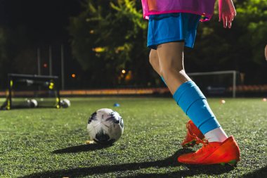 Bir futbol oyuncusunun futbol topunu, stadyumu, spor kıyafetlerini, aktif hayatı tekmelemeye hazırlandığı yakın çekim. Yüksek kalite fotoğraf