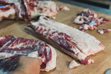 Gıda endüstrisinde et işlemenin yakın plan çekimlerinde işçiler çiğ domuz kesip buzdolabında depoluyorlar. Yüksek kalite fotoğraf