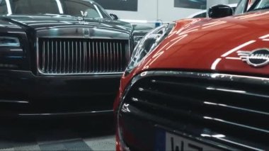 26.03.2024. Varşova, Polonya. Satılık yeni arabaları ve kiralık iş yerleri olan lüks bir galeride dikkatlice park edilmiş araçlar sergileniyor. Yüksek kalite 4k görüntü