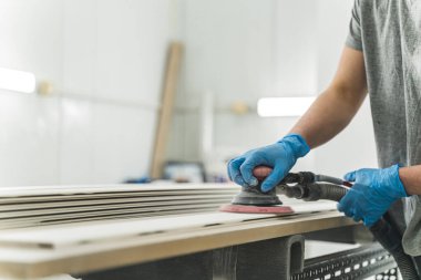 Marangoz marangozluk veya marangozluk atölyesinde zımpara kağıdı ile ahşap öğütüyor. Marangozlukta çalışan elektrikli zımpara makinesi. Yüksek kalite fotoğraf
