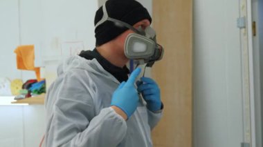 Bir marangoz atölyede ahşap boyamak için koruyucu maske takıyor. Yüksek kalite 4k görüntü