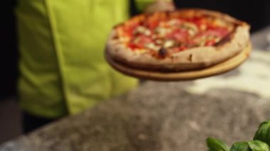 Şef büyük lezzetli bir pizza tutuyor, İtalyan mutfağı konsepti. Yüksek kalite 4k görüntü