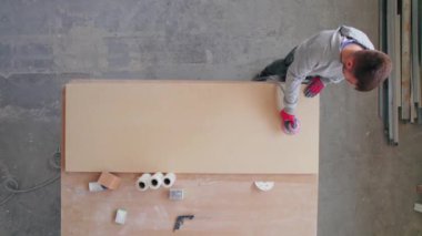 Ahşap fabrikasında elektrikli aletler ve kerestelerle çalışan yetişkin bir adam, tepeden tırnağa. Yüksek kalite 4k görüntü