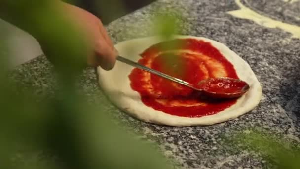 Χέρια Προσθέτοντας Φρέσκια Σάλτσα Ντομάτας Στη Ζύμη Πίτσας Συστατικά Της — Αρχείο Βίντεο