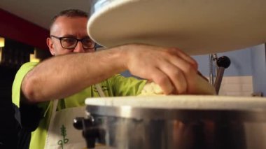 Şef pizza hamurunu pres makinesine koyuyor, modern makine. Yüksek kalite 4k görüntü