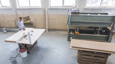 Marangoz, marangozhanedeki ahşap masada ekipmanla çalışıyor. Kadın bir marangozhanede çalışıyor. Yüksek kalite fotoğraf