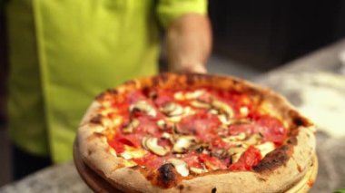 Şef kabuklu pizza tutuyor, şef restoranda çalışıyor. Yüksek kalite 4k görüntü