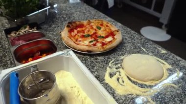 Restoran mutfağında çalışan bir adam geleneksel pizza hazırlıyor. Yüksek kalite 4k görüntü