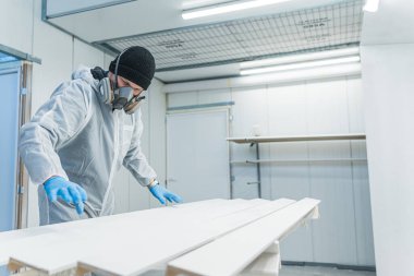 Üniformalı marangoz işyerindeki tahta parçaları üzerinde çalışıyor. Yüksek kalite fotoğraf