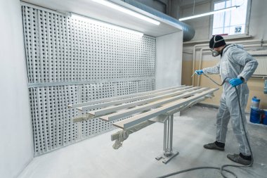 Marangoz, sprey tabancayla odun boyuyor, boya işinde çalışan marangoz. Yüksek kalite fotoğraf