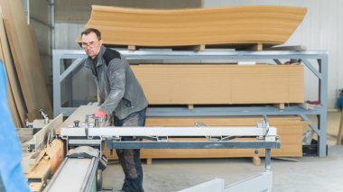 Kafkasyalı marangoz atölyesinde ahşap bir yapı üzerinde çalışıyor. Endüstriyel bir konsept. Yüksek kalite fotoğraf