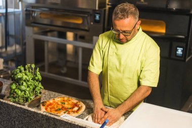 Profesyonel şef pizza hamuru hazırlıyor, arka planda elektrikli fırın. Yüksek kalite fotoğraf