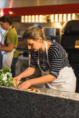 Kadın restoran mutfağında pizza hazırlıyor, fırın konsepti. Yüksek kalite fotoğraf