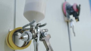 Duvarda asılı bir sprey tabancanın yakın plan çekimi, marangoz servisi. Yüksek kalite 4k görüntü