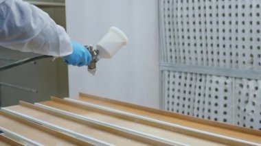 İşçi, detayın düz yüzeyini sprey boyayla kaplıyor. Yüksek kalite 4k görüntü