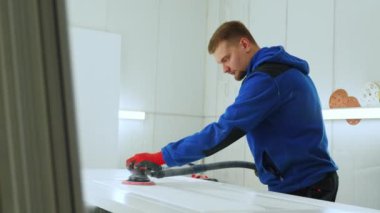 Marangoz atölyedeki ahşap üzerinde rastgele bir yörünge zımparası kullanıyor, ahşap işçiliği kavramı. Yüksek kalite 4k görüntü