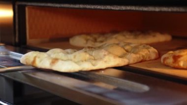 Pizza hamurunu fırında pişirirken, yemek pişirirken yakın çekim. Yüksek kalite 4k görüntü
