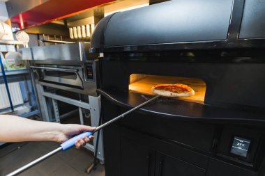Aşçı elektrikli fırından pizza çıkartıyor, mutfak aplikasyonları. Yüksek kalite fotoğraf