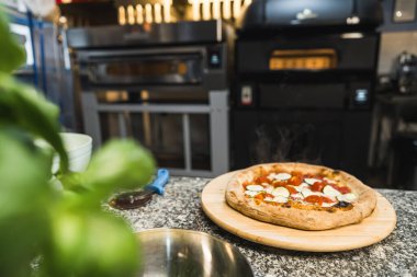 Mutfak masasında, restoranda, fırın konseptinde tam boy pizza. Yüksek kalite fotoğraf