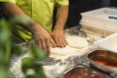 Pizza için hamur hazırlayan yetenekli şef, pizza yapma süreci, erkek ellerine odaklan. Yüksek kalite fotoğraf