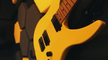 Diğerleriyle birlikte duvarda asılı modern sarı elektro gitar, gitarlar. Yüksek kalite 4k görüntü