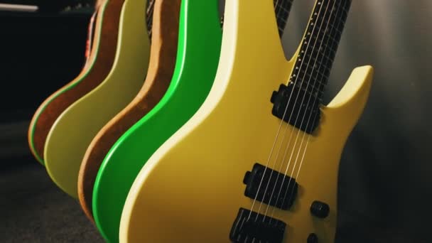 スタジオの緑と黄色のベースギターのクローズアップ 低音ギターのコレクション 高品質の4K映像 — ストック動画